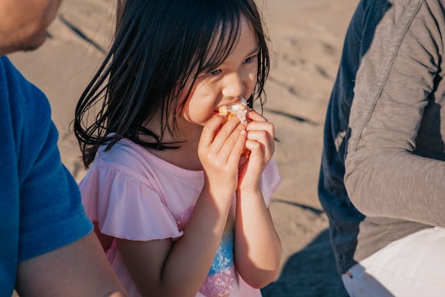 young girl enjoying a snack at the beach